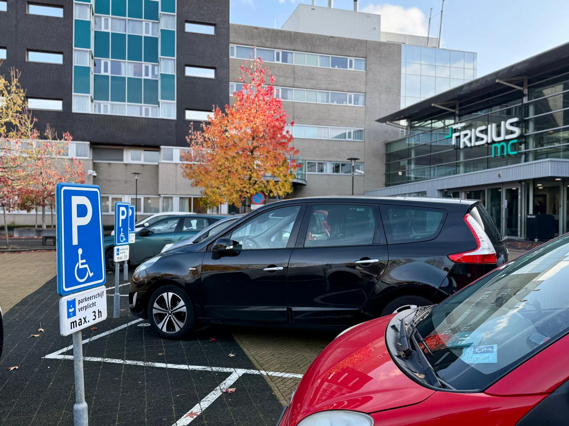 Zwarte auto geparkeerd op gehandicaptenparkeerplaats voor Frisius MC Heerenveen.