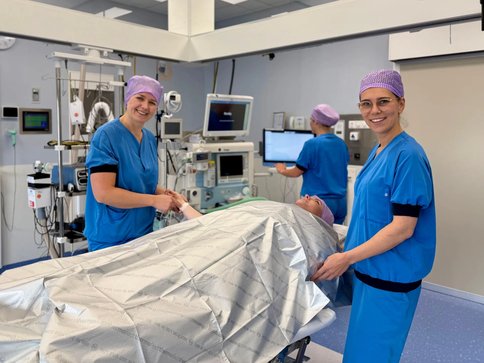Medisch personeel bereidt een patiënt voor op een operatie in de operatiekamer.