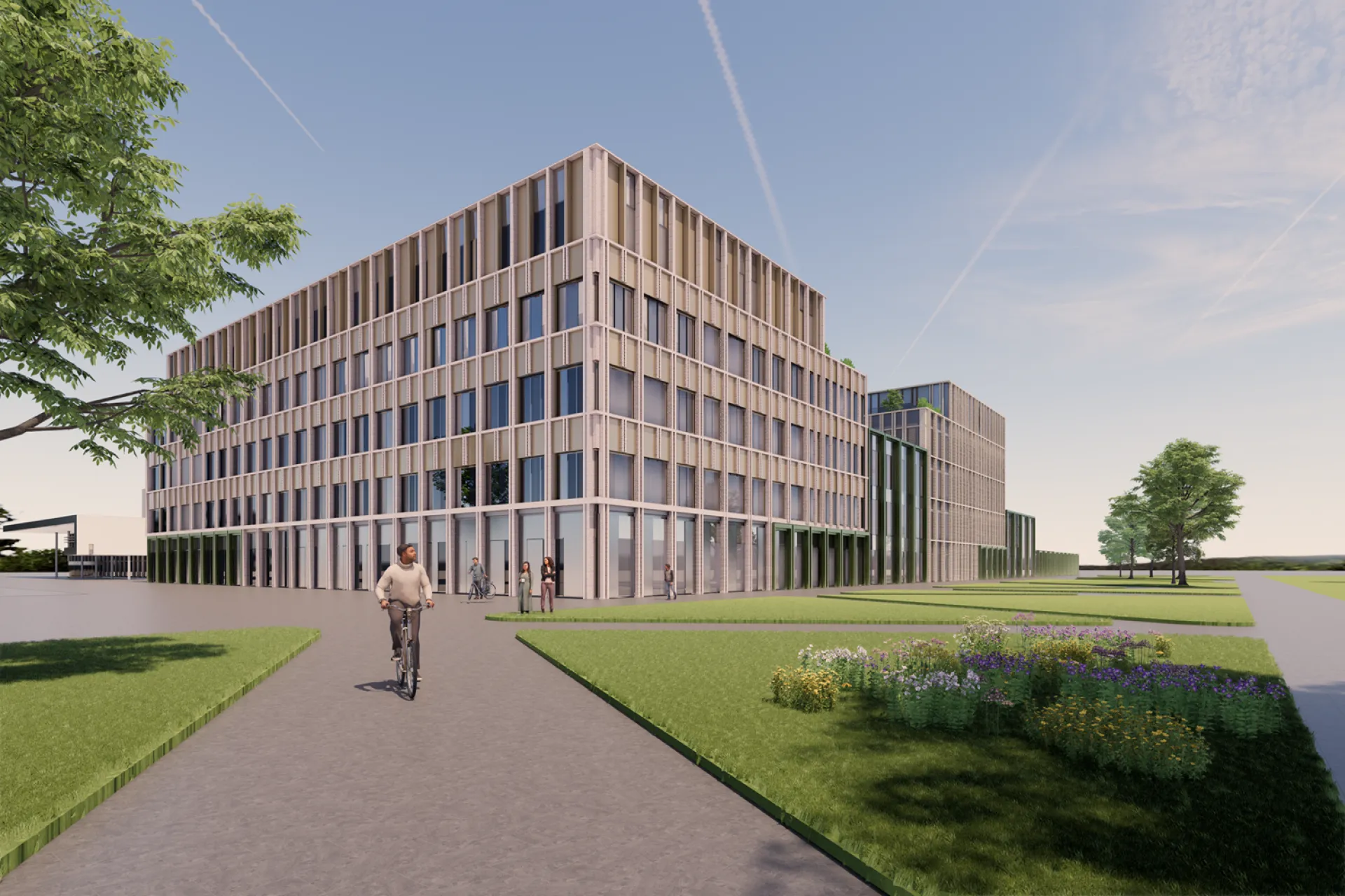 Nieuwbouw Frisius MC Leeuwarden omgeven door groen met een fietser op het pad.