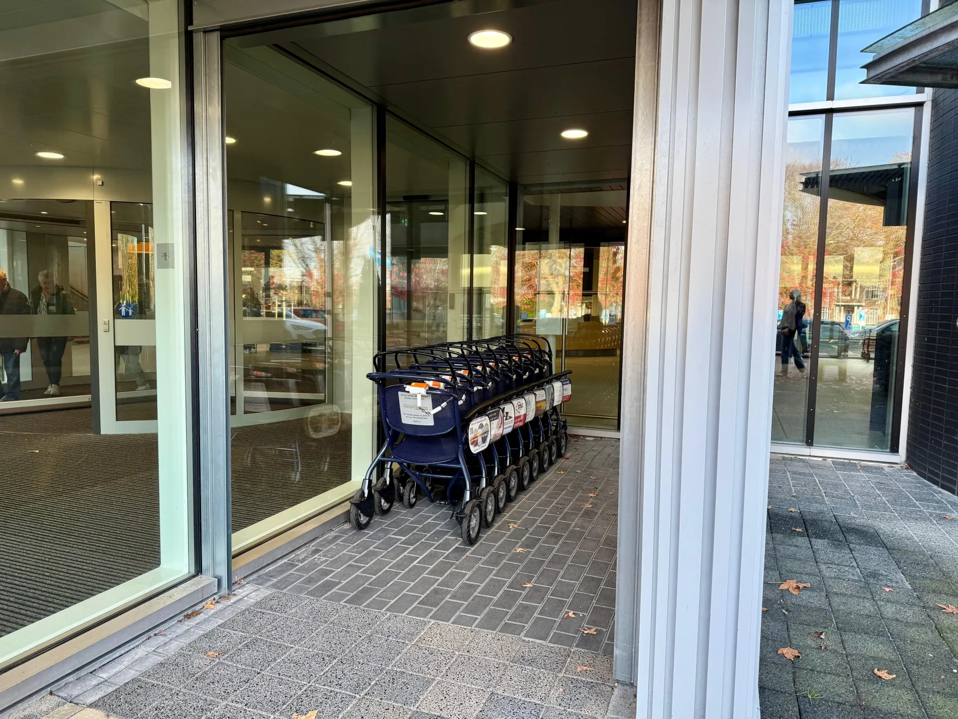 Een rij rolstoelen bij de ingang van het ziekenhuis.