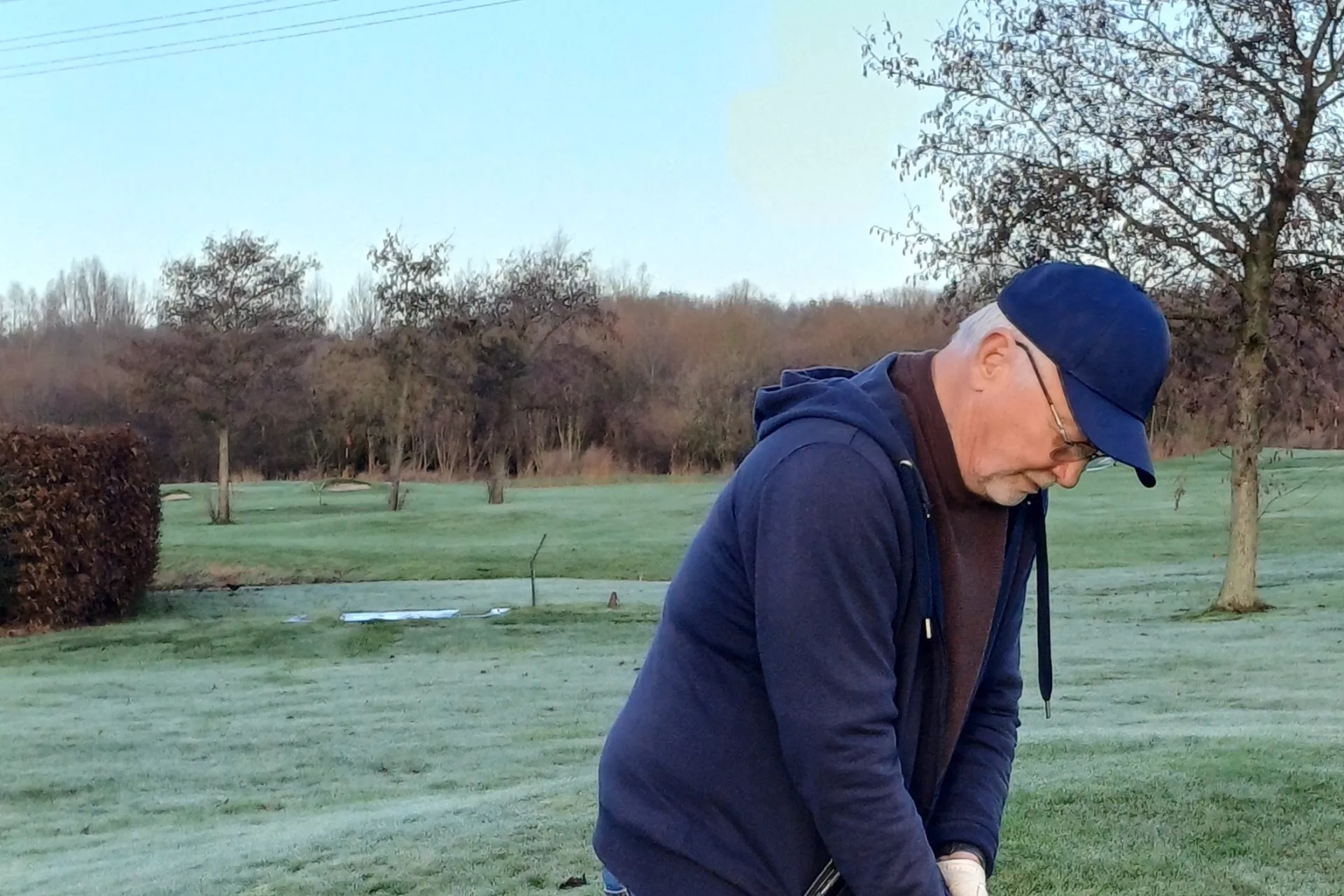 Man speelt golf op een open veld.