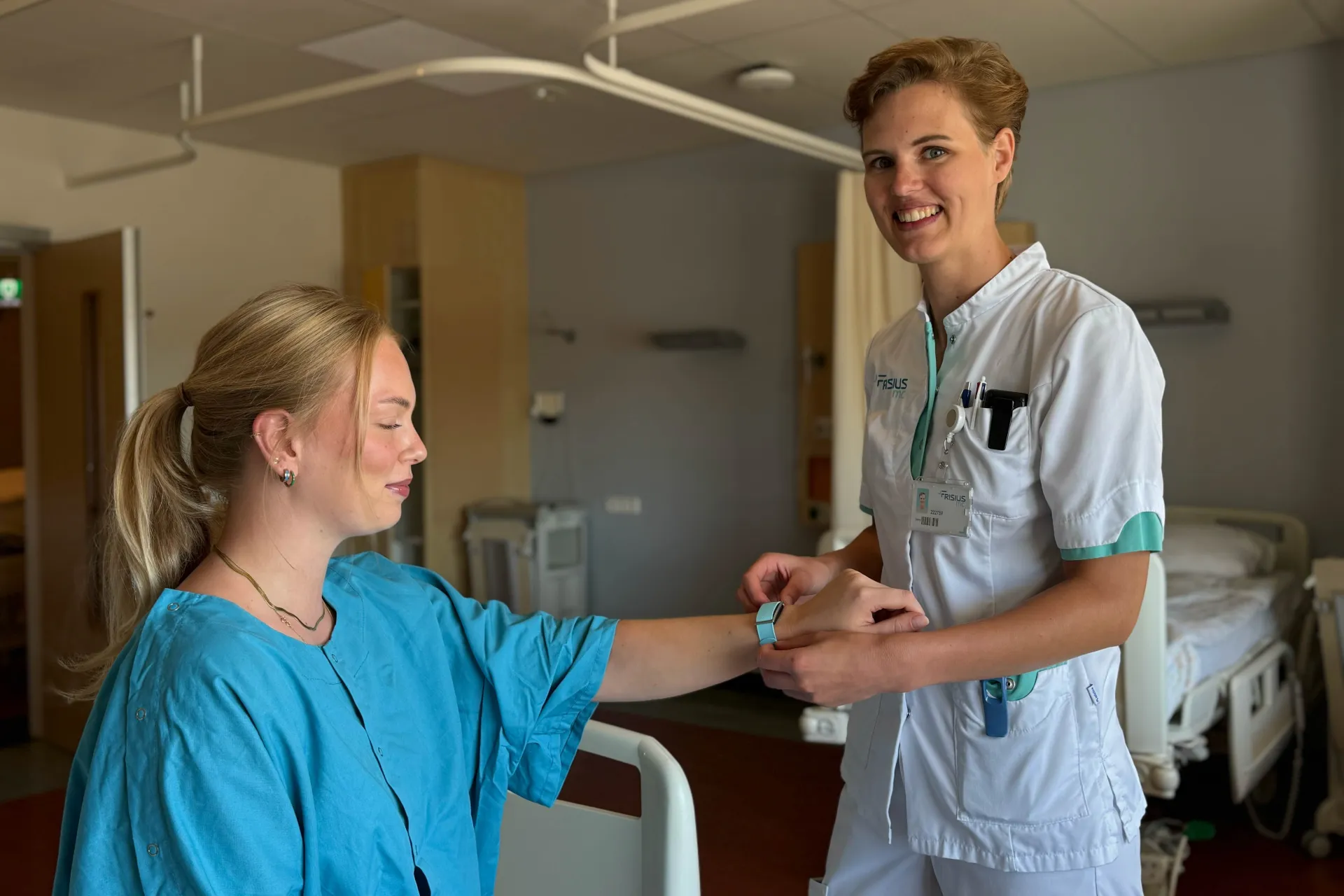 Een verpleegkundige sluit de cardiowatch Corsano aan bij een pati137ent.