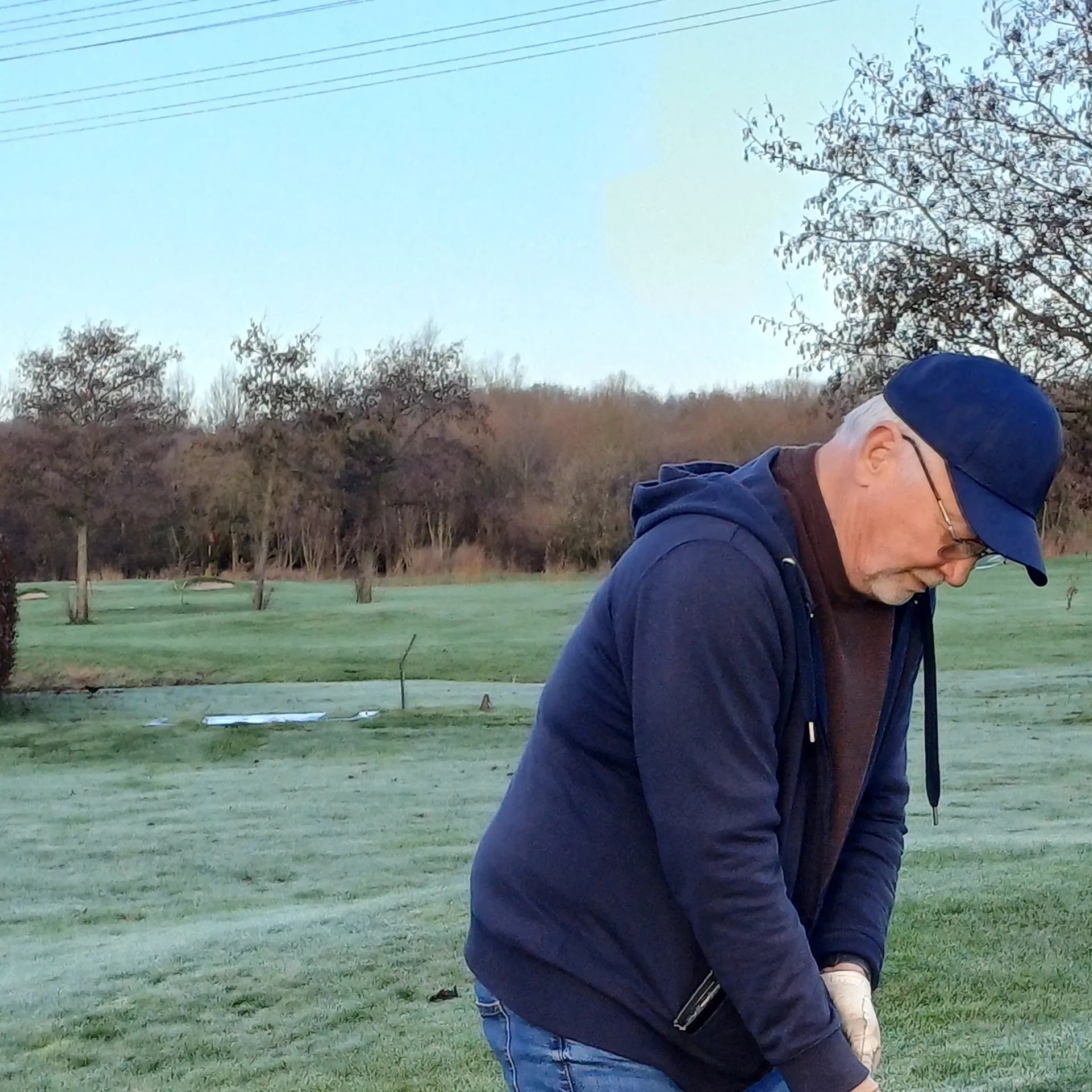 Man speelt golf op een open veld.